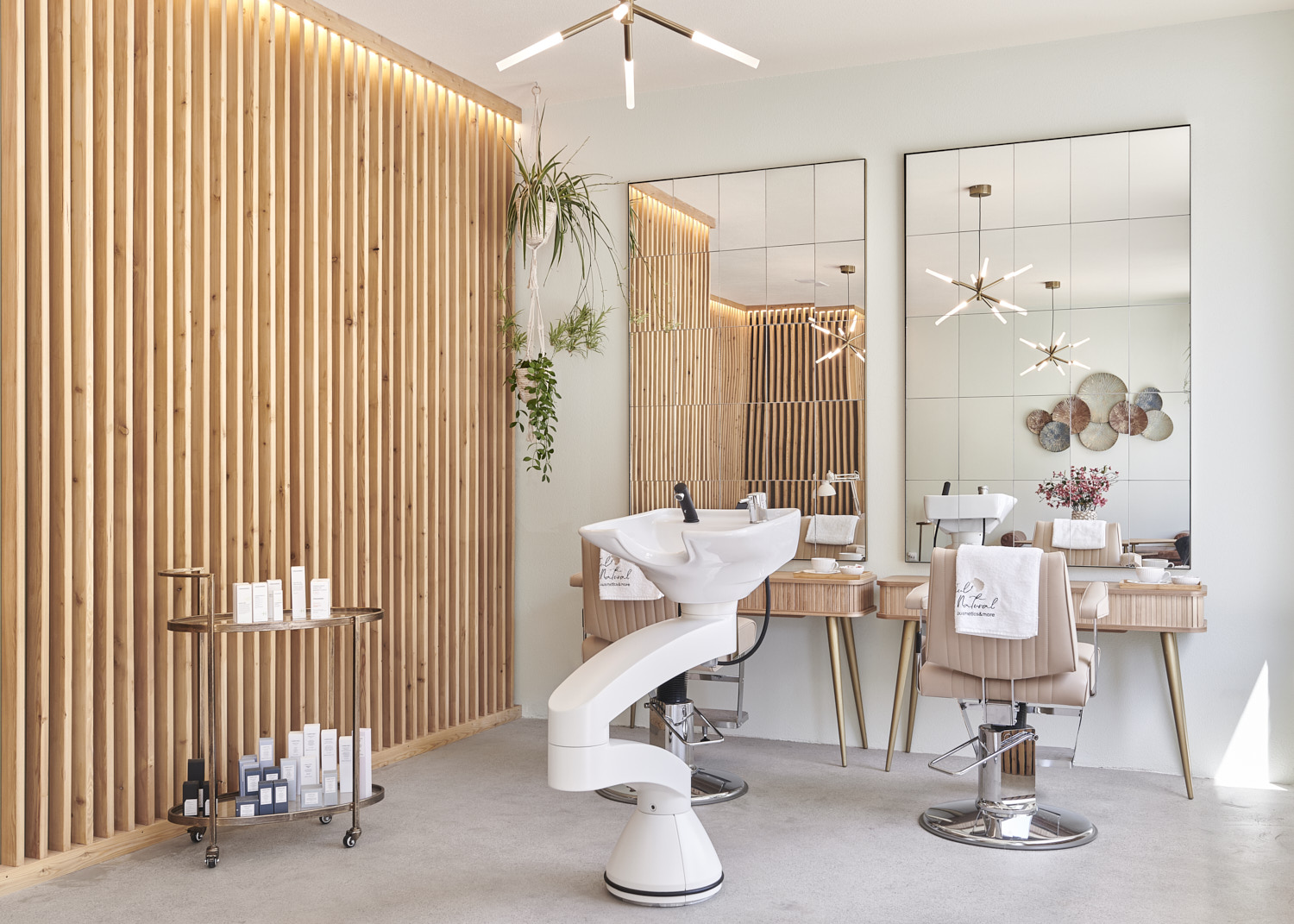 Coiffeur-Arbeitsplätze vor Spiegeln und Holzlamellenwand