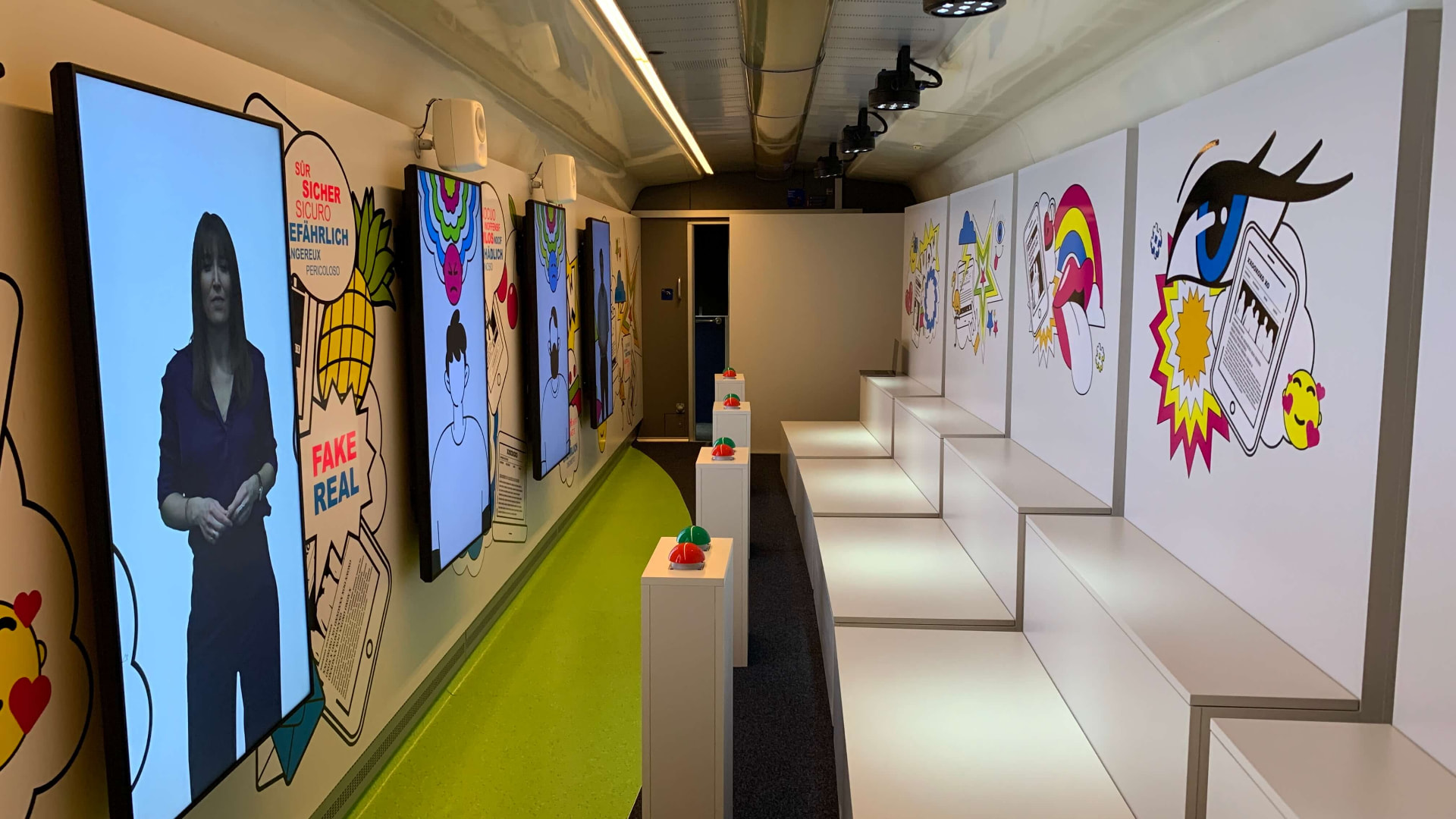 Innenraum des Schulzugs mit Screens, Illustrationen und Sitzpodesten